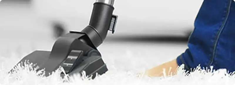 Close-up of a professional vacuuming a white carpet in Fairfield.